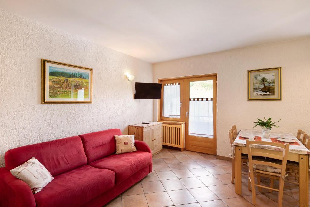 uma sala de estar com um sofá vermelho e uma mesa em Residence Attila Panorama em Livigno