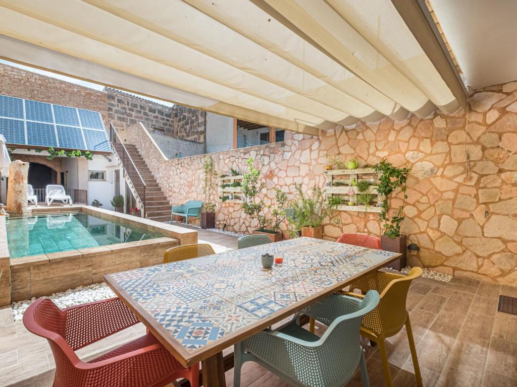 een patio met een tafel en stoelen en een zwembad bij Holiday Home Cordella - SNY101 by Interhome in Santanyi