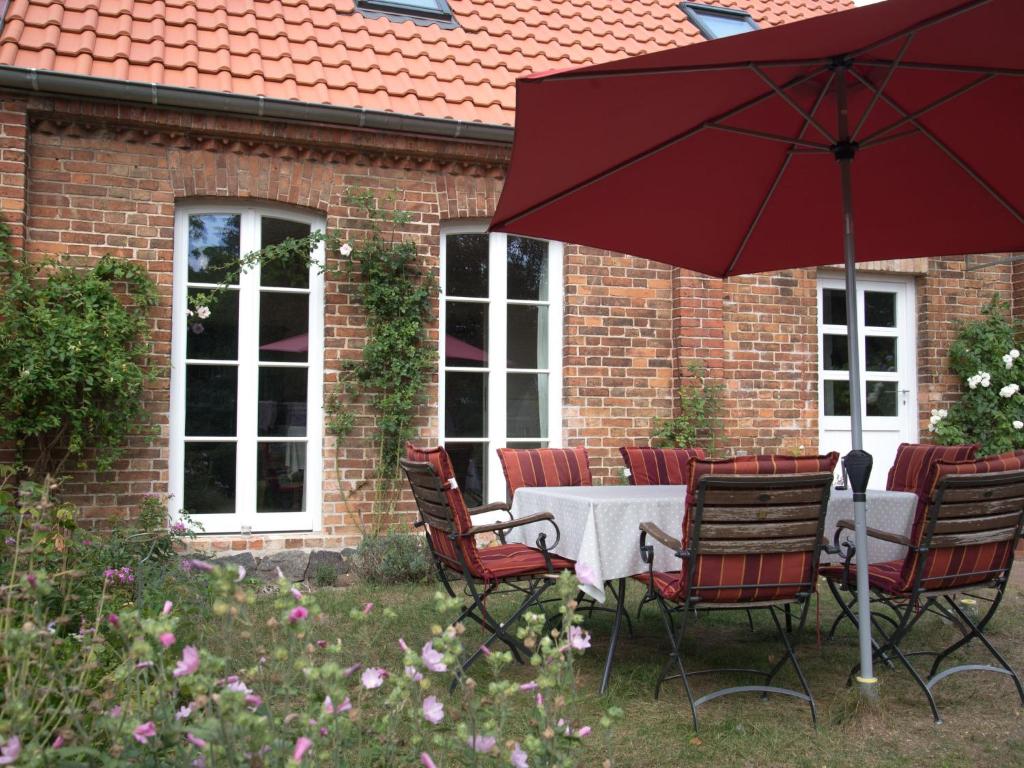a table with chairs and an umbrella in front of a building at Holiday Home Kranich by Interhome in Troja