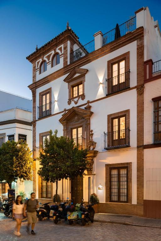 a large white building with people walking in front of it at Casa del Gobernador by Época Suites in Seville
