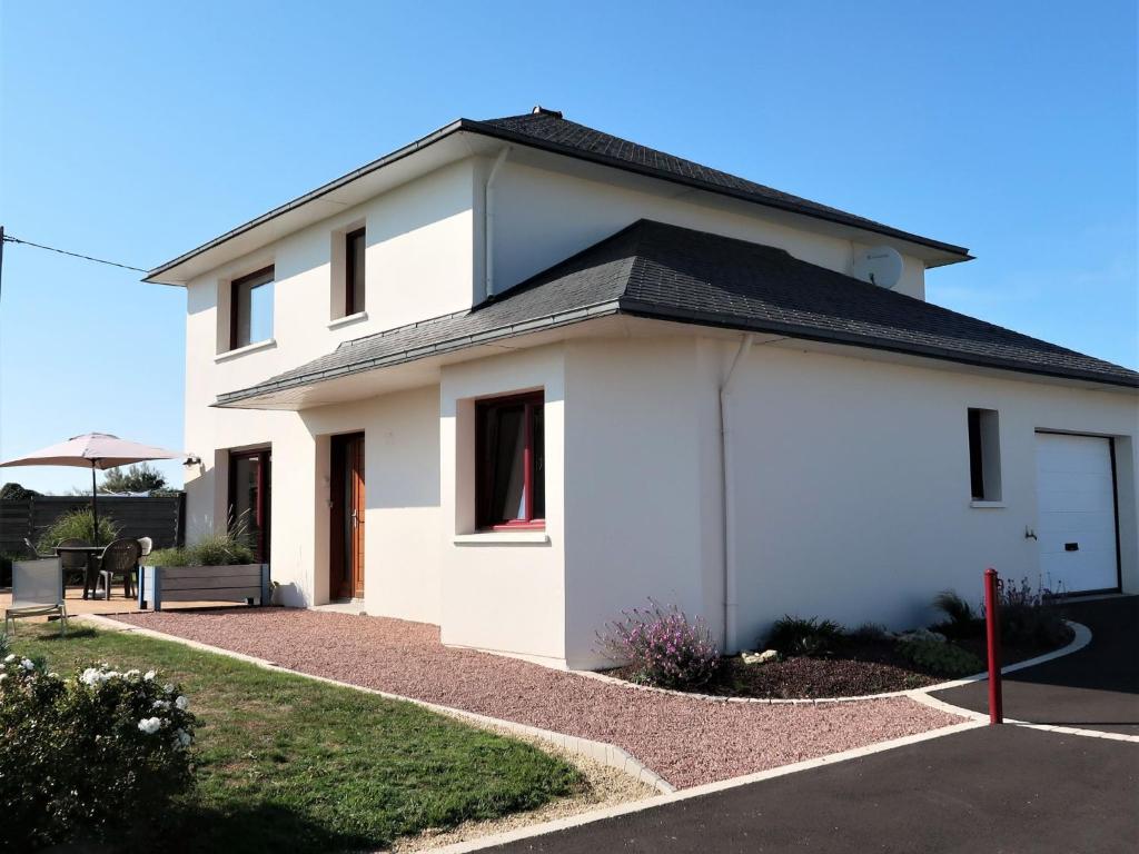 une maison blanche avec un toit noir dans l'établissement Holiday Home Ti Koantig - KER216 by Interhome, à Kerlouan