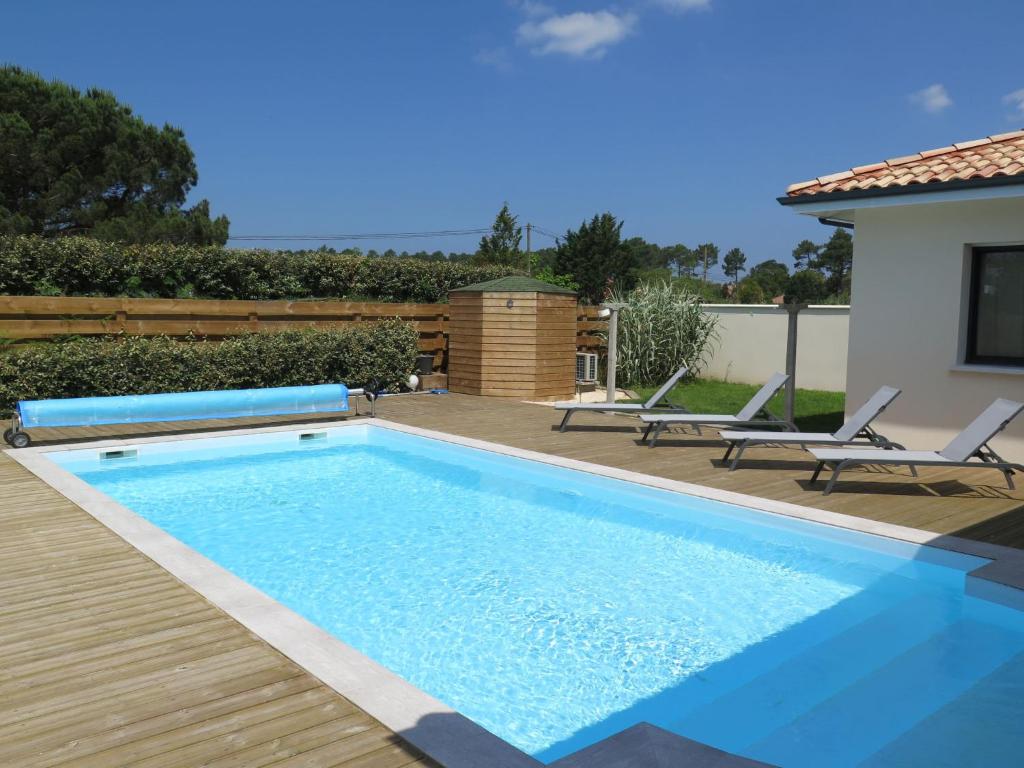 una piscina con 2 sillas y una casa en Villa Le Bosquet - MES180 by Interhome, en Messanges