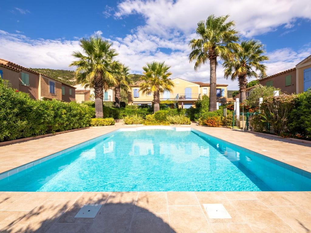 a swimming pool in a yard with palm trees at Holiday Home Les Olivades by Interhome in Plan-de-la-Tour