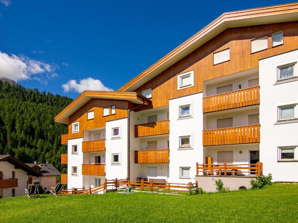 um grande edifício de apartamentos com um quintal verde em Apartment Cisles by Interhome em Selva di Val Gardena