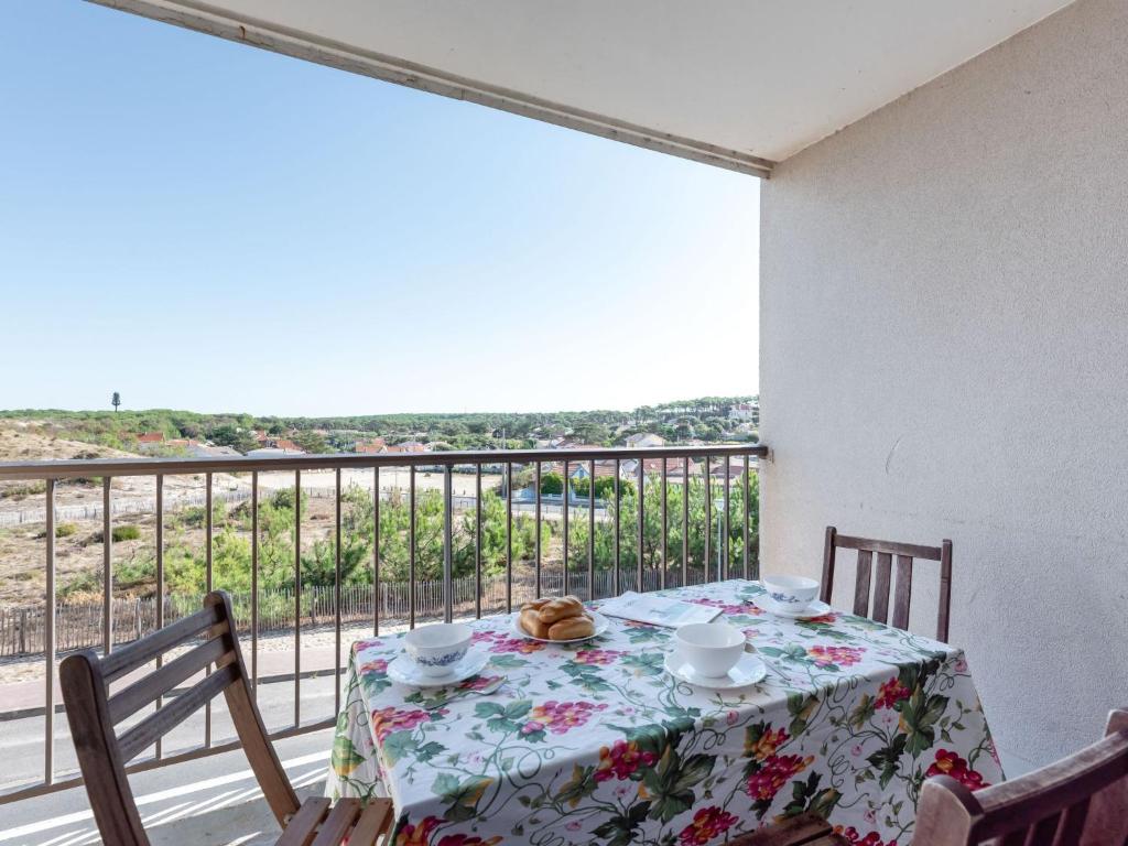 a dining room table with a view of a balcony at Apartment Les Sables d'Argent-4 by Interhome in Lacanau-Océan