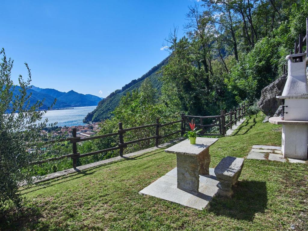 ławka siedząca w trawie obok płotu w obiekcie Holiday Home Residenza La Sassicaia by Interhome w mieście Dongo