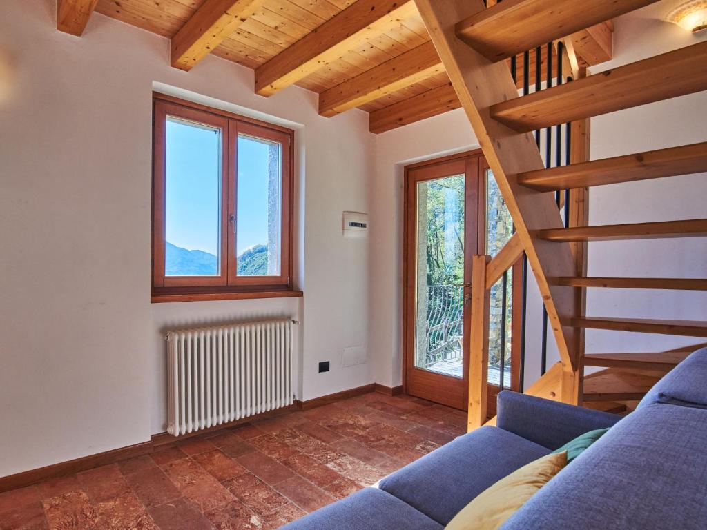 salon z niebieską kanapą i schodami w obiekcie Holiday Home Residenza La Sassicaia by Interhome w mieście Dongo