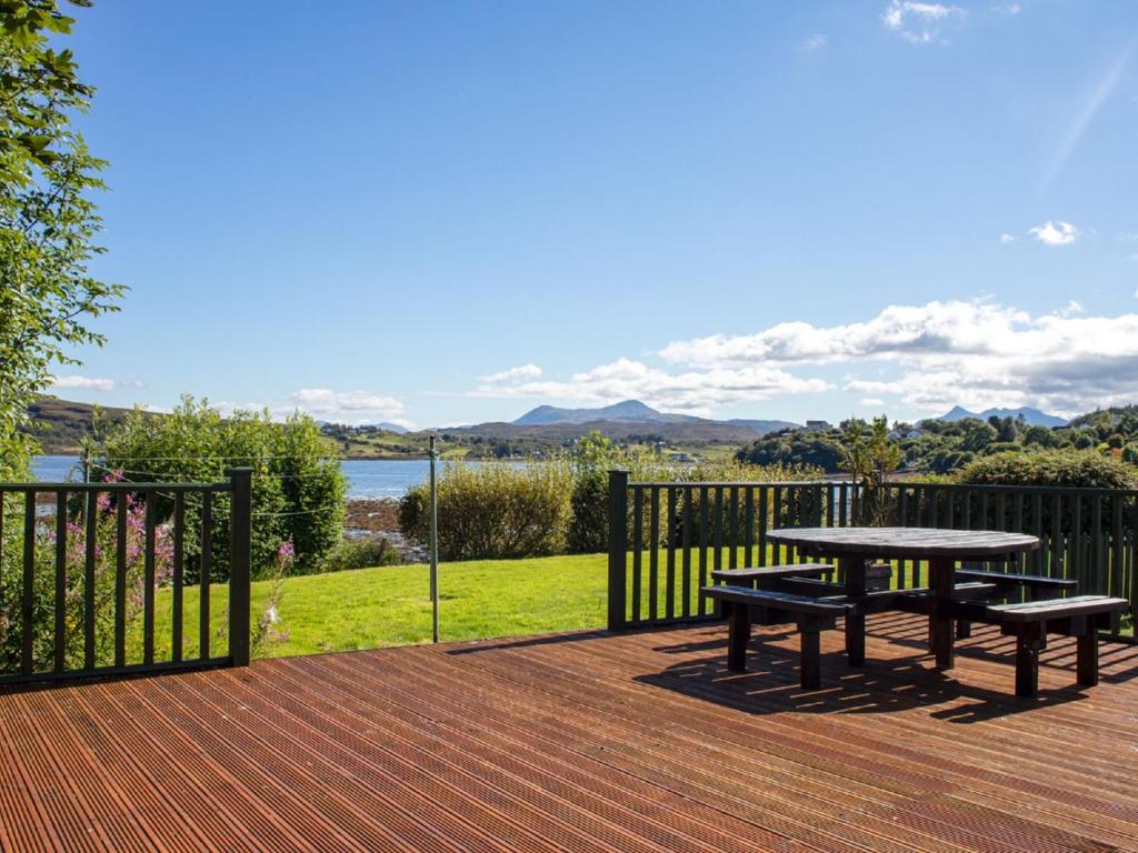 a picnic table on a deck with a view of the water at Holiday Home Viewfield by Interhome in Portree