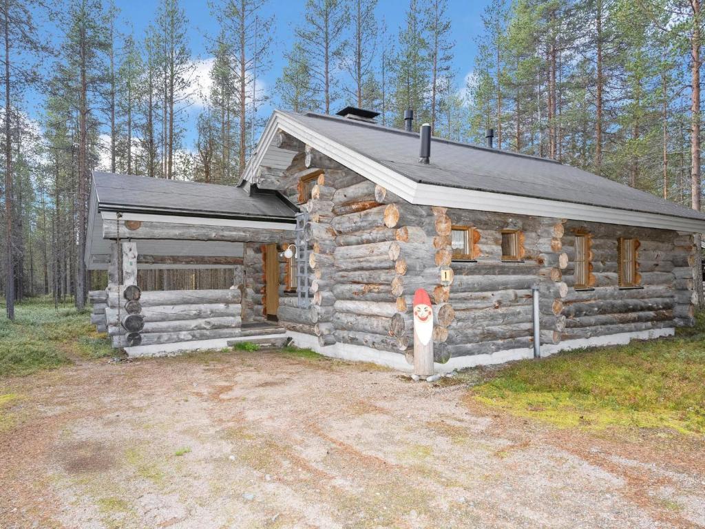 une cabane en rondins dotée d'une bouche de feu devant elle dans l'établissement Holiday Home Rukanlumous 1 by Interhome, à Ruka