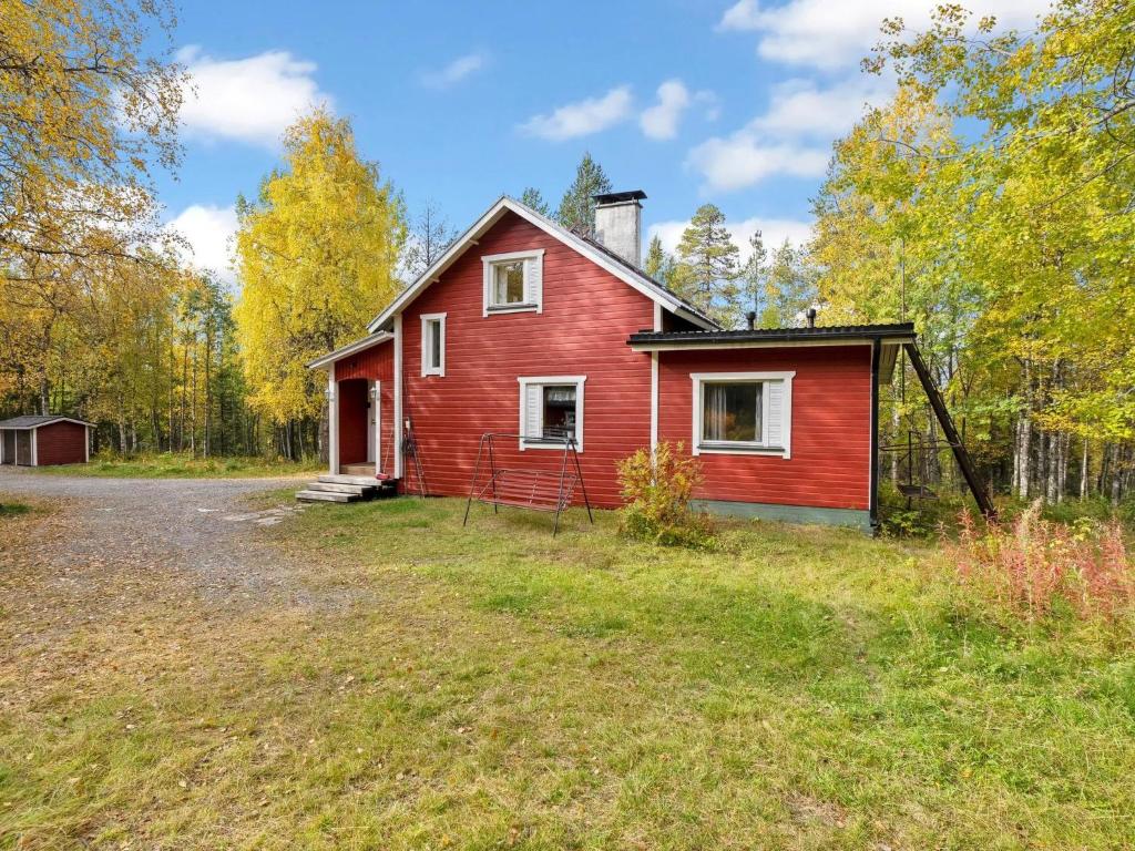 a red house in the middle of a field at Holiday Home Vuorimäki by Interhome in Ruka