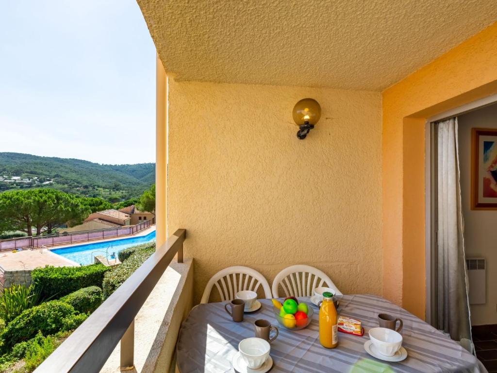 - une table et des chaises avec vue sur la piscine dans l'établissement Apartment La Gaillarde-1 by Interhome, aux Issambres