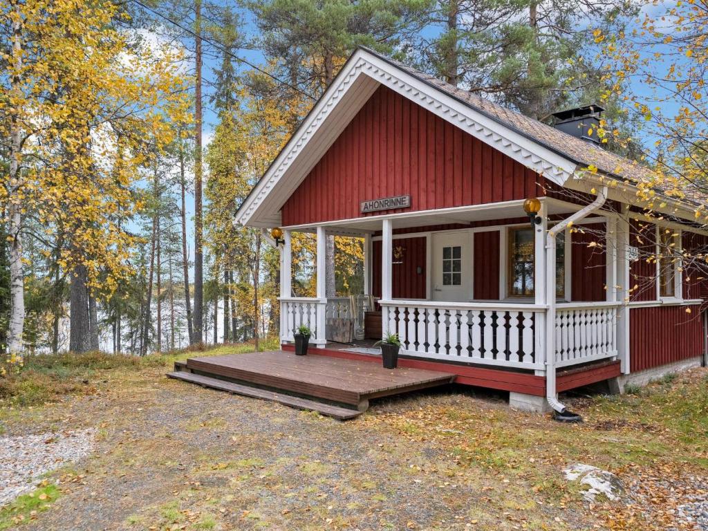 una casa roja con terraza en el bosque en Holiday Home Kaukosaaren ahonrinne by Interhome, en Ruka