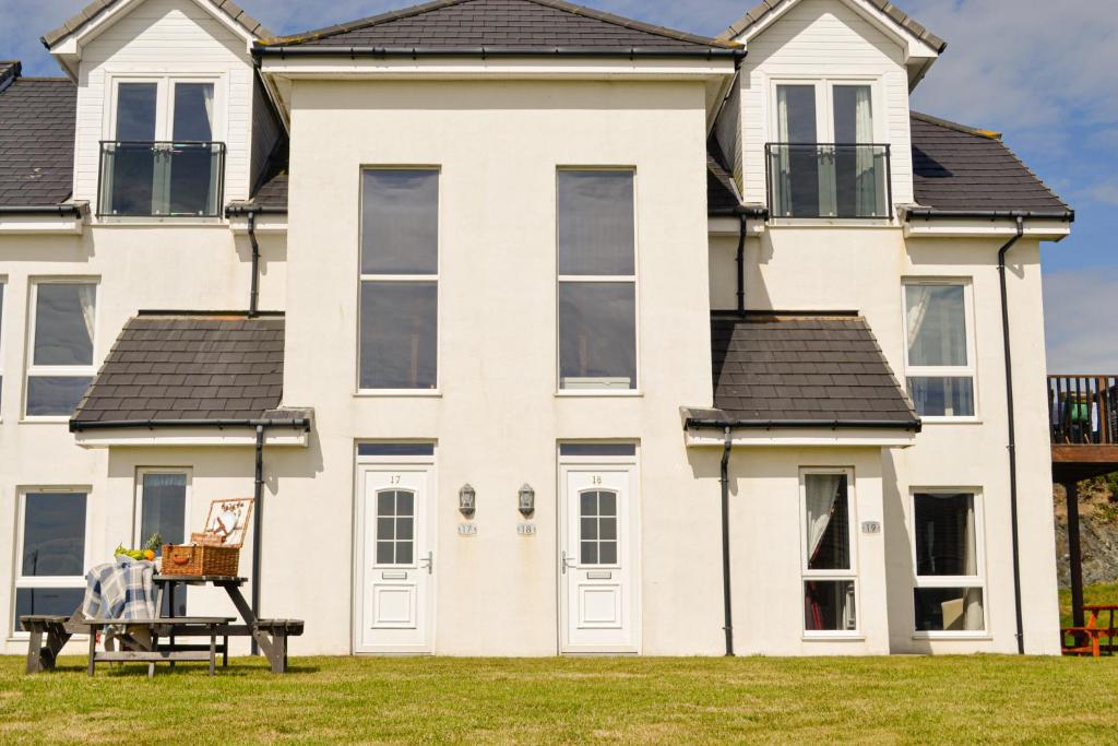 uma casa branca com uma mesa em frente em The Fairways em Portpatrick