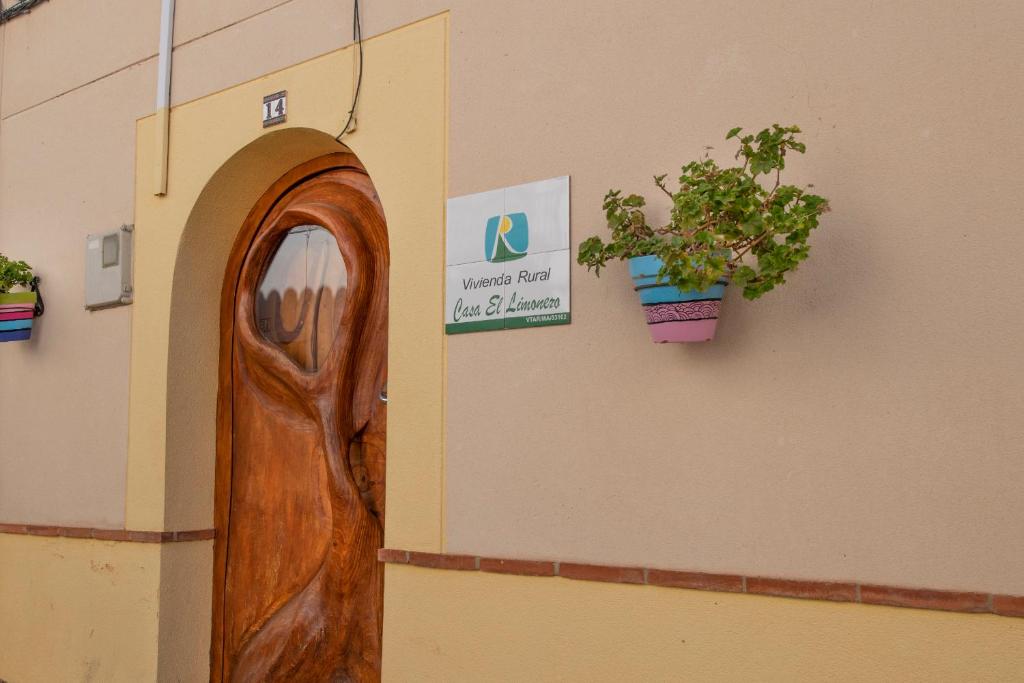una puerta de madera en un edificio con una maceta en Encantadora casa de pueblo para 7 pax con gran Terraza, en Jimera de Líbar