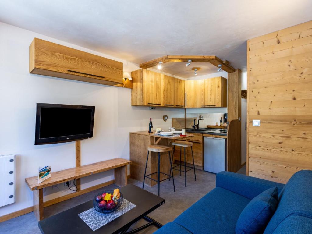 un salon avec un canapé bleu et une cuisine dans l'établissement Studio Rond Point des Pistes - Val Claret-13 by Interhome, à Tignes