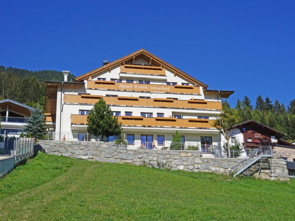 ein großes weißes Gebäude mit einer Steinmauer in der Unterkunft Apartment Ladis-10 by Interhome in Ladis