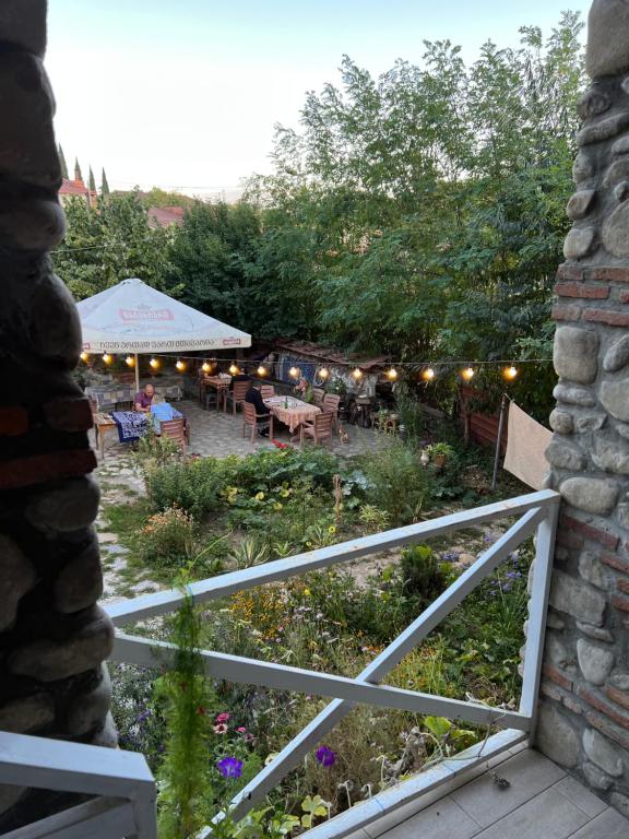 uma vista para um jardim com uma cerca e uma tenda em Guest House Lali em Signagi