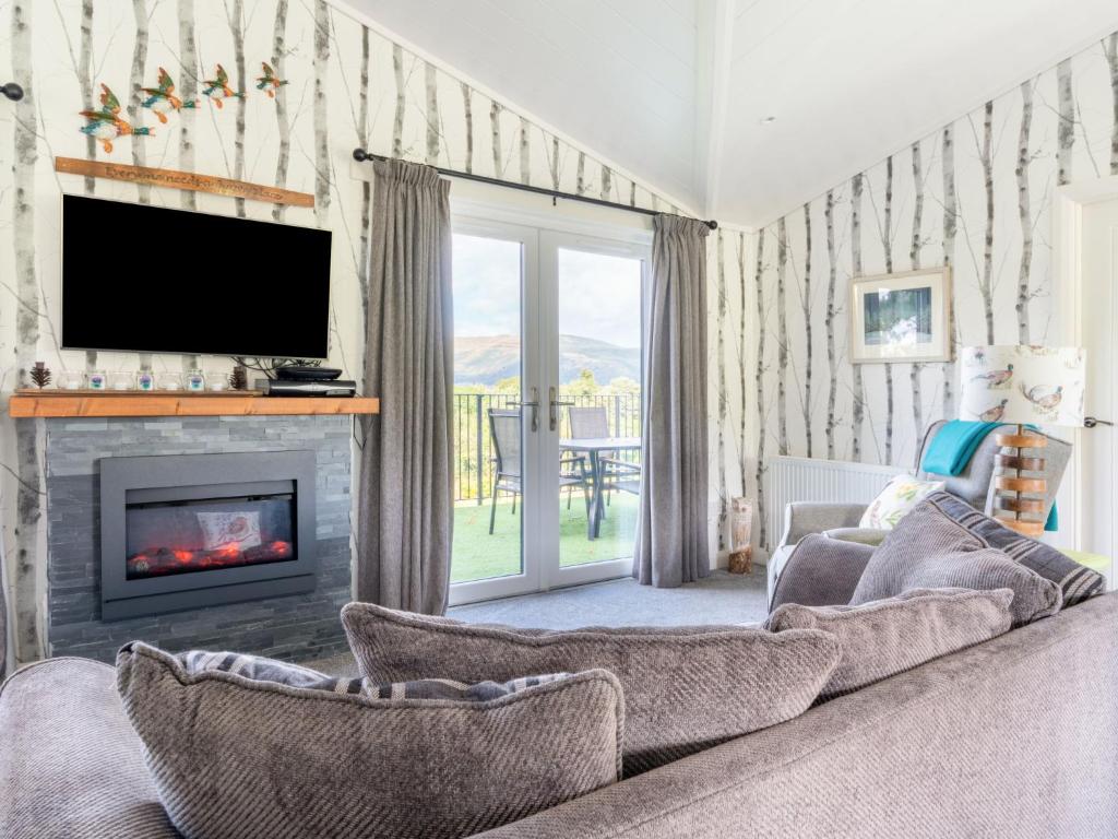 a living room with a couch and a fireplace at Chalet Loch Leven Lodge 16- Robin's Nest by Interhome in Kinross