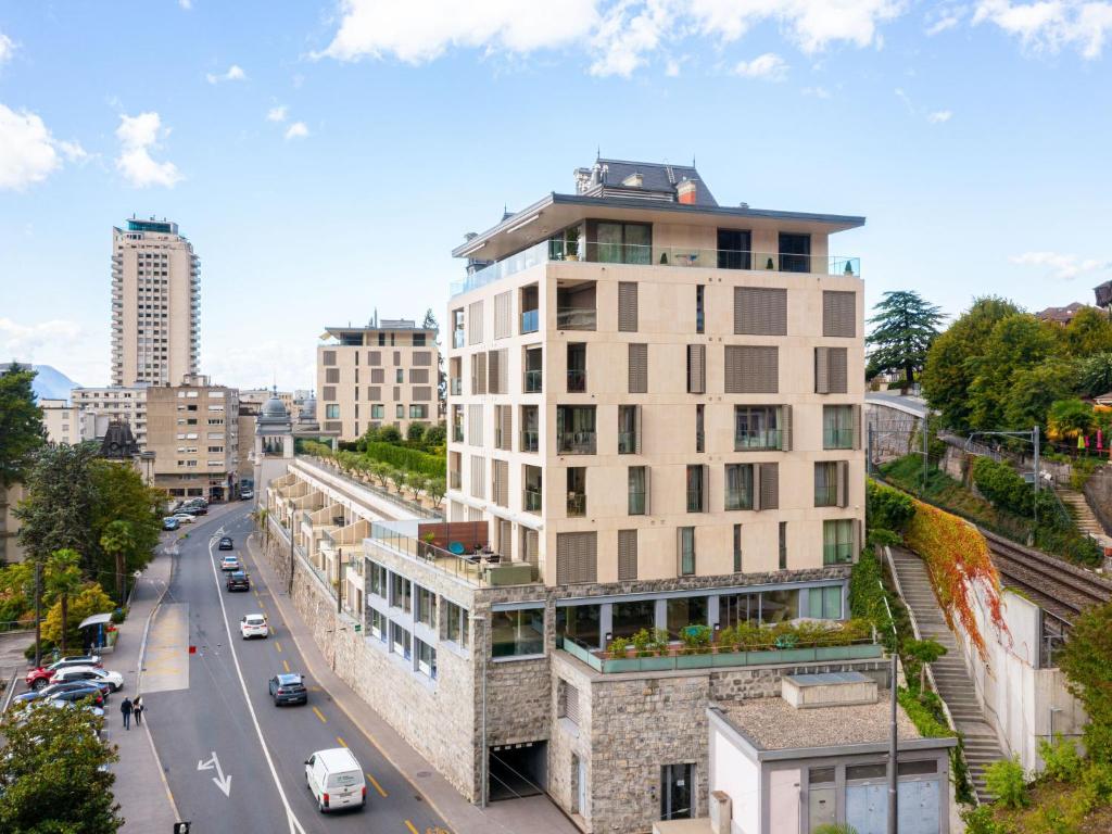 ein hohes weißes Gebäude an der Straßenseite in der Unterkunft Apartment Le Belvédère D2-6 by Interhome in Montreux