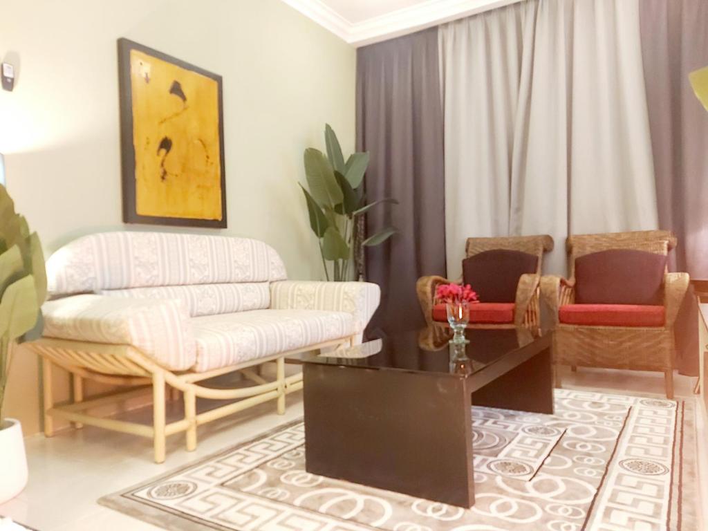 sala de estar con sofá y 2 sillas en Islamic Homestay Apartment Kundang, Rawang en Rawang