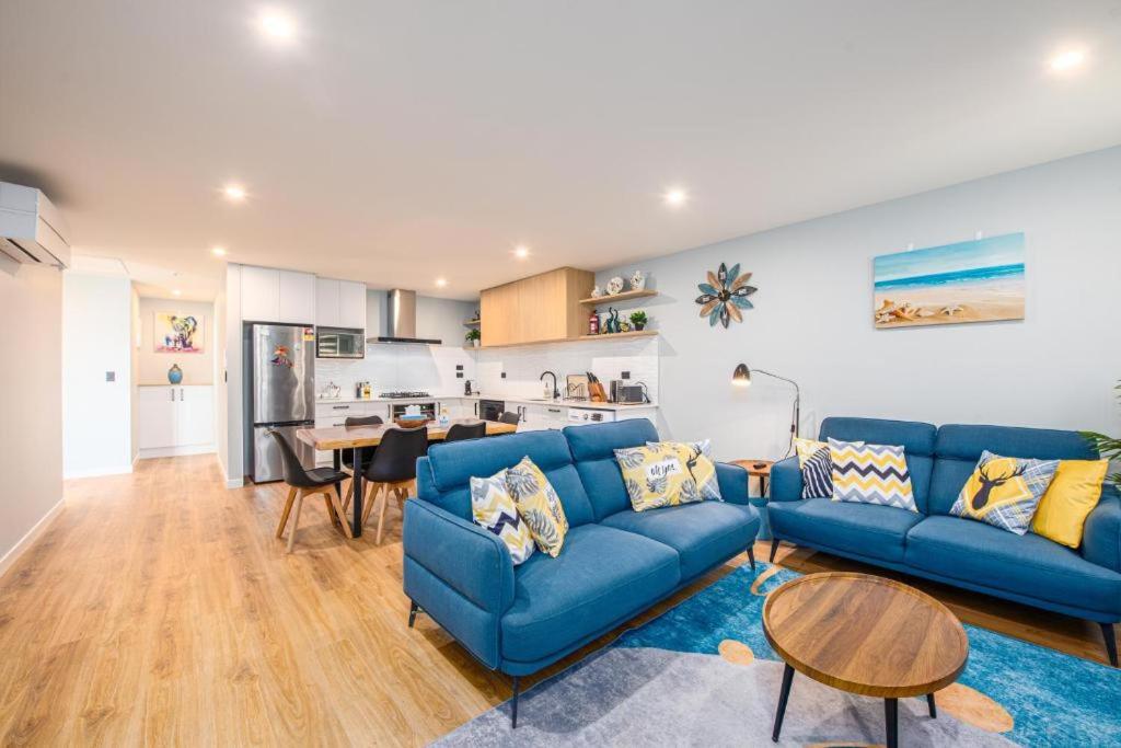 a living room with a blue couch and a table at 37 Galaxy B in Lake Tekapo