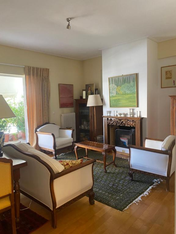 uma sala de estar com mobiliário e uma lareira em Traditional And Spacious Apartment In Neo Psychiko em Atenas