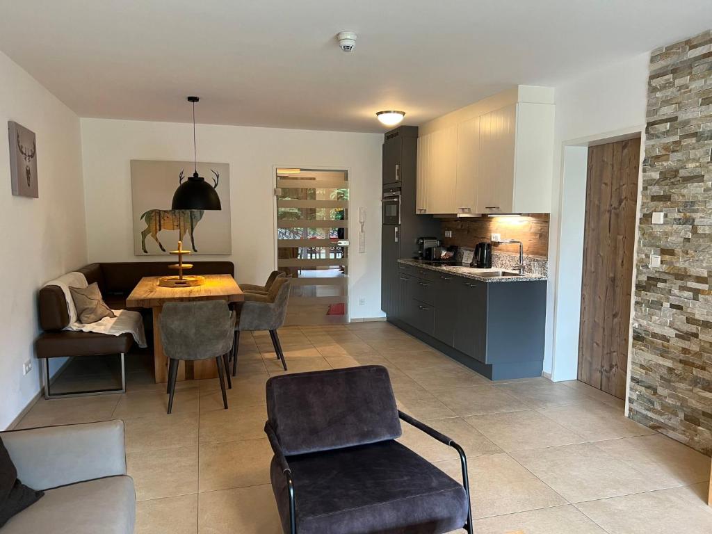 a kitchen and living room with a table and chairs at Apartment Ski & Golf Suites Zell am See by Interhome in Zell am See