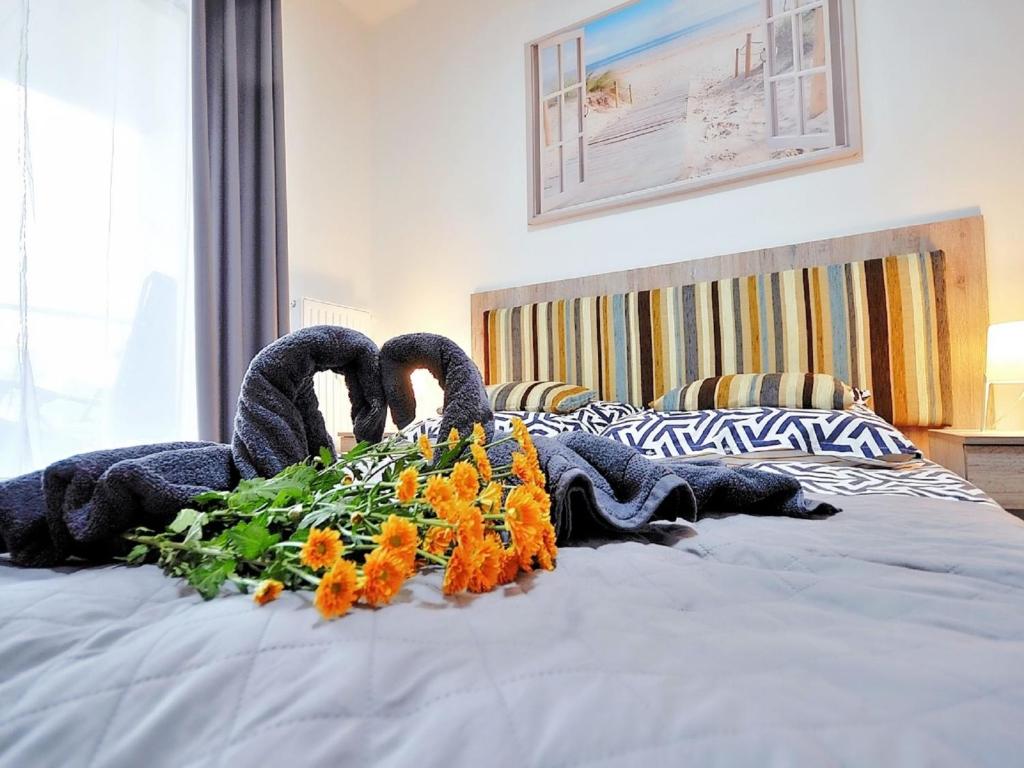 Dos cisnes hechos de flores en una cama en Apartment Szum Morza-5 by Interhome en Kołobrzeg