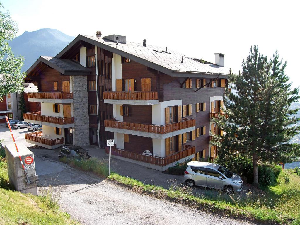 a building with a car parked in front of it at Apartment Les Crêtes 1-4 by Interhome in Veysonnaz