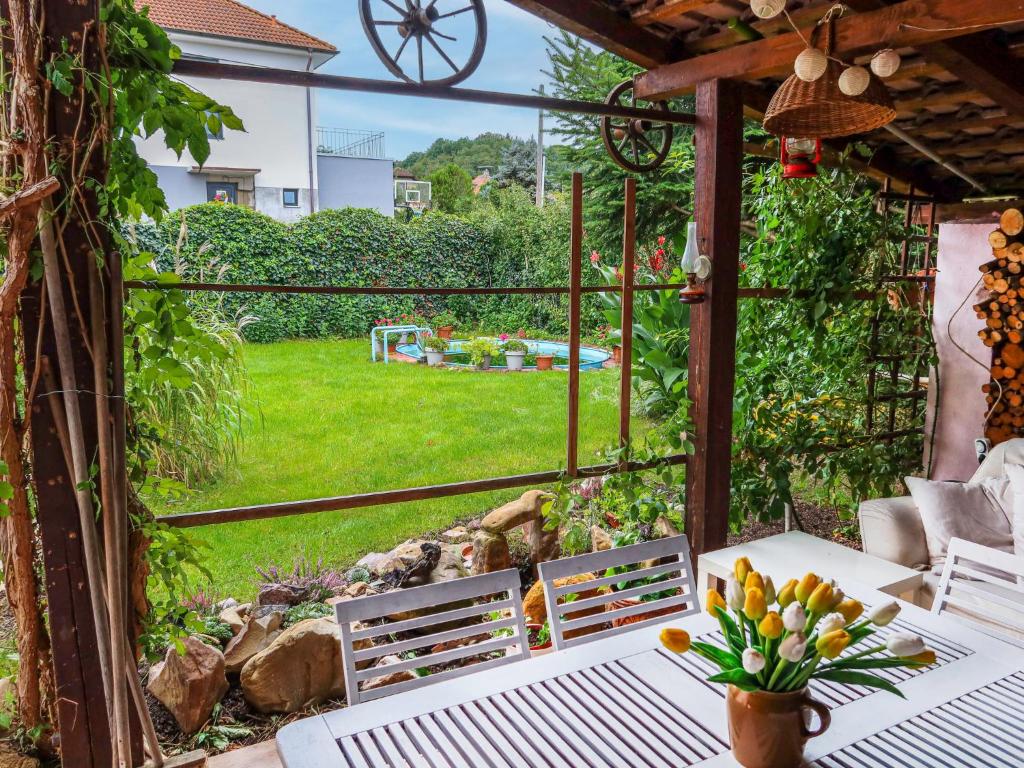 a patio with a table and chairs and a view of a yard at Holiday Home Řevnice by Interhome in Řevnice
