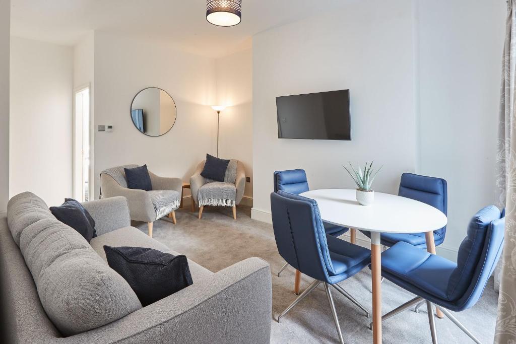 uma sala de estar com um sofá, uma mesa e cadeiras em Host & Stay - High Street Apartments em Caernarfon