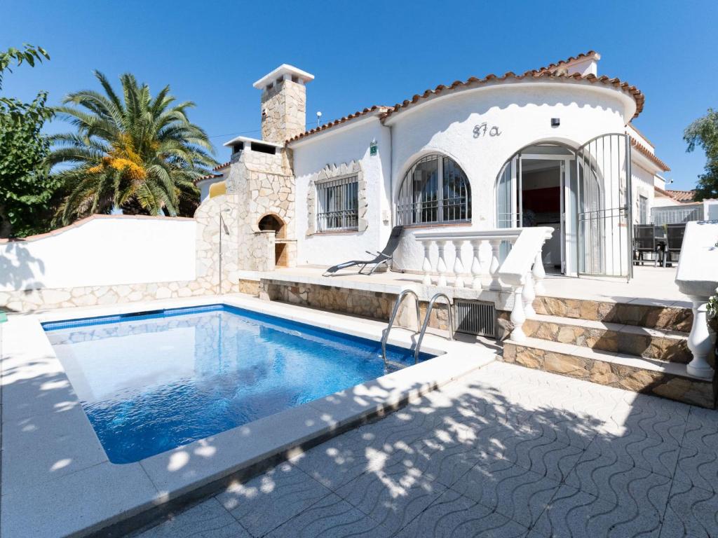 eine Villa mit einem Pool vor einem Haus in der Unterkunft Holiday Home Flamenco by Interhome in Empuriabrava