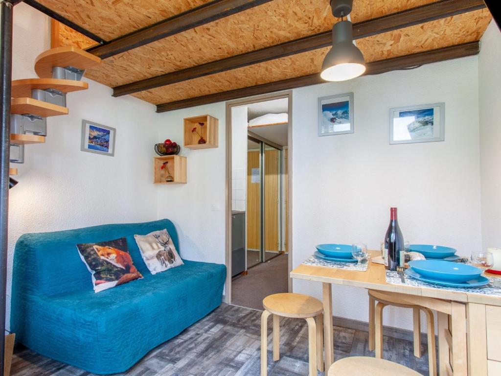 un salon avec un canapé bleu et une table dans l'établissement Studio Rond Point des Pistes - Val Claret-19 by Interhome, à Tignes