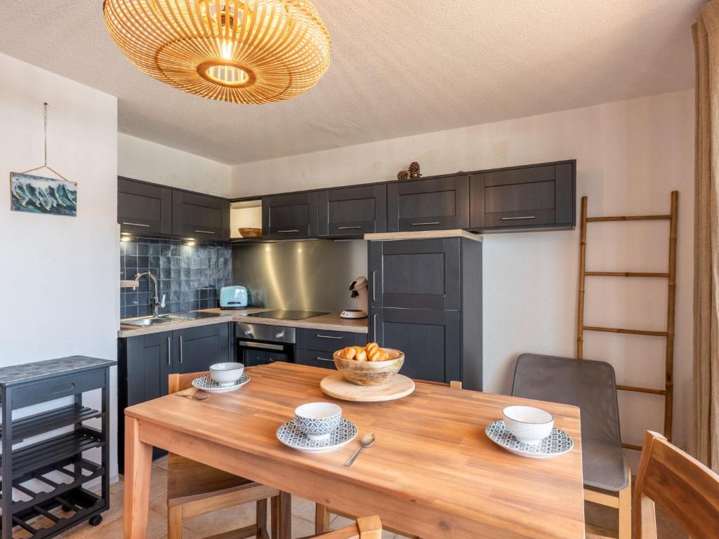 uma cozinha com uma mesa de madeira com tigelas de fruta em Apartment Ortal Océan-9 by Interhome em Lacanau-Océan