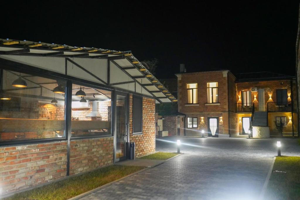 a brick building with a pavilion at night at Hotel and Hostel Ticiani 15 in Kutaisi