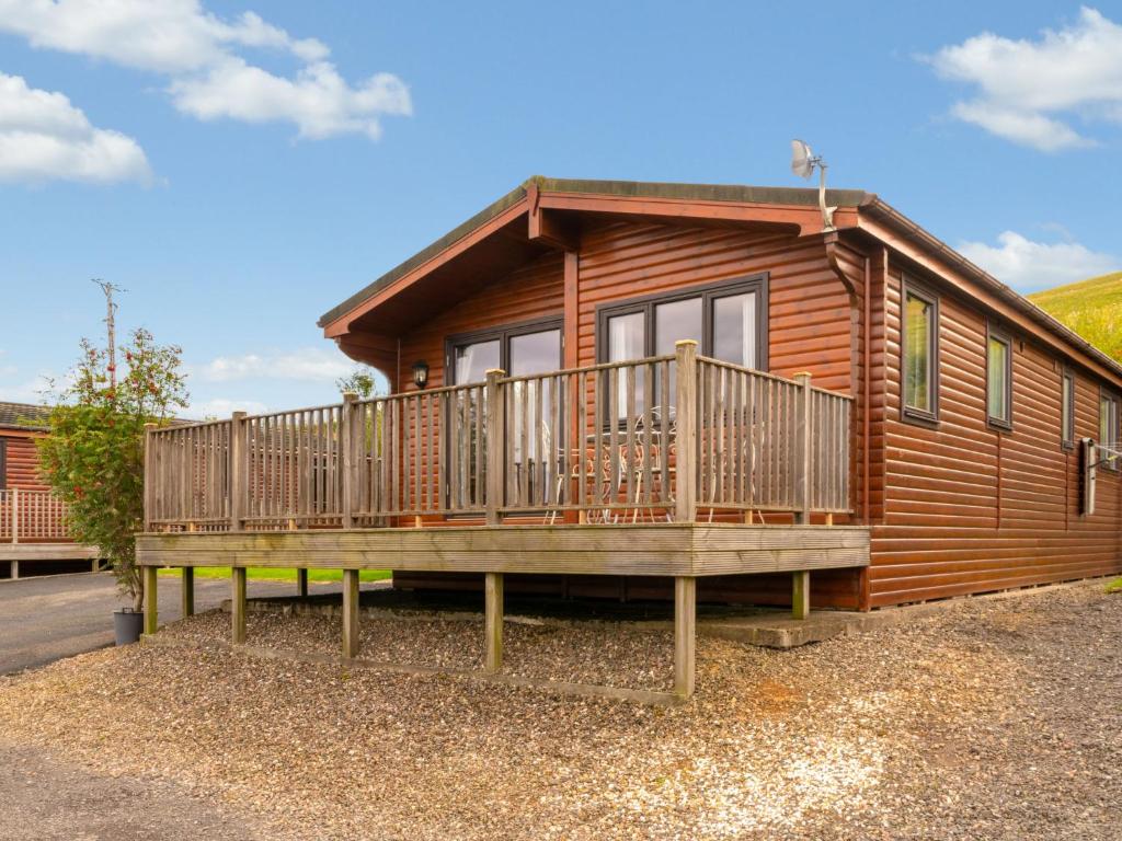 a log cabin with a large porch and a deck at Chalet Lodge 9 by Interhome in Kinross