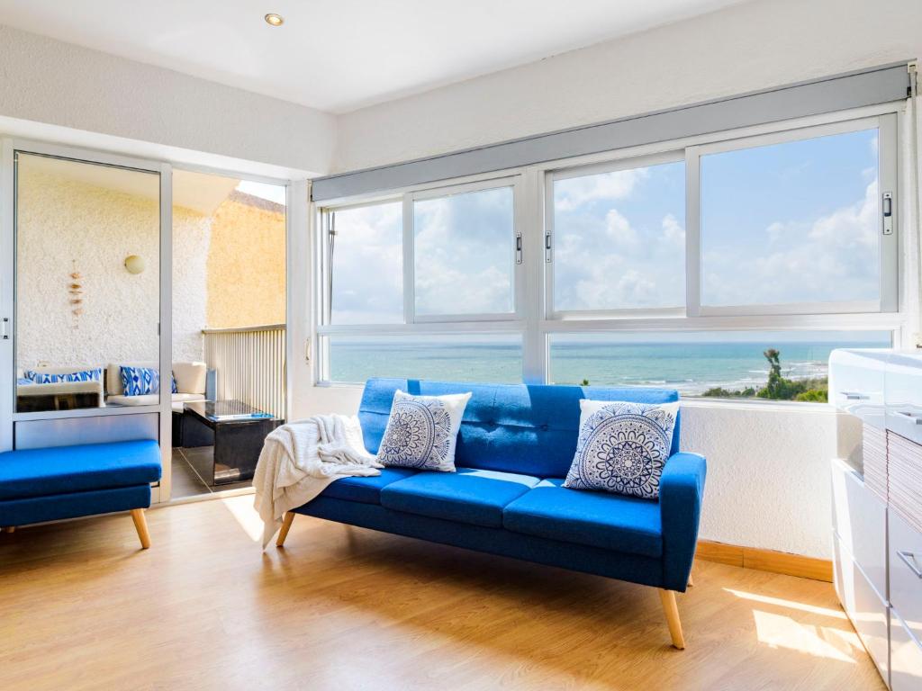 - un canapé bleu dans le salon avec vue sur l'océan dans l'établissement Apartment Kivu by Interhome, à Oropesa del Mar