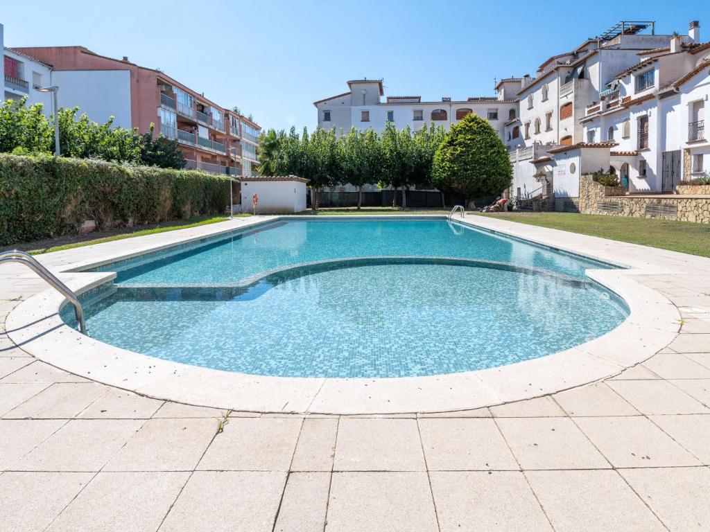 una gran piscina en un patio con edificios en Apartment Puigmal by Interhome, en Empuriabrava