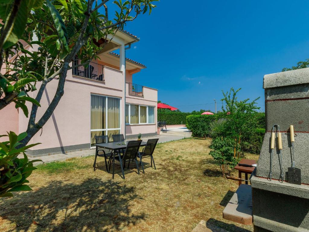 eine Terrasse mit einem Tisch und Stühlen vor einem Haus in der Unterkunft Holiday Home Goga by Interhome in Nedeščina