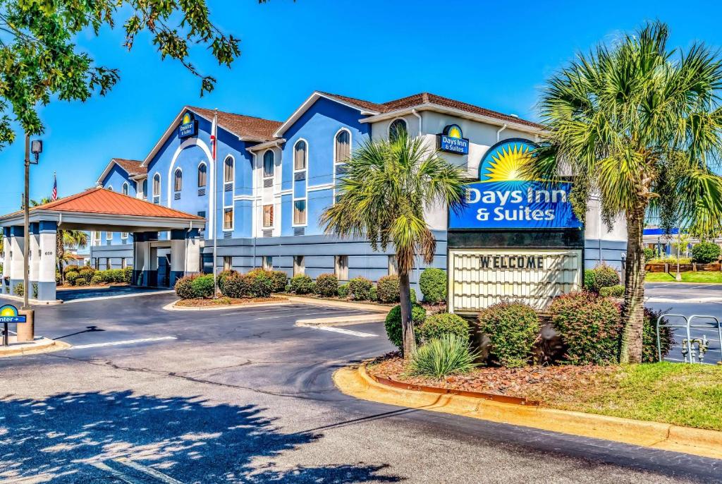 Una posada de día y suites firman frente a un edificio en Days Inn & Suites by Wyndham Prattville-Montgomery en Prattville