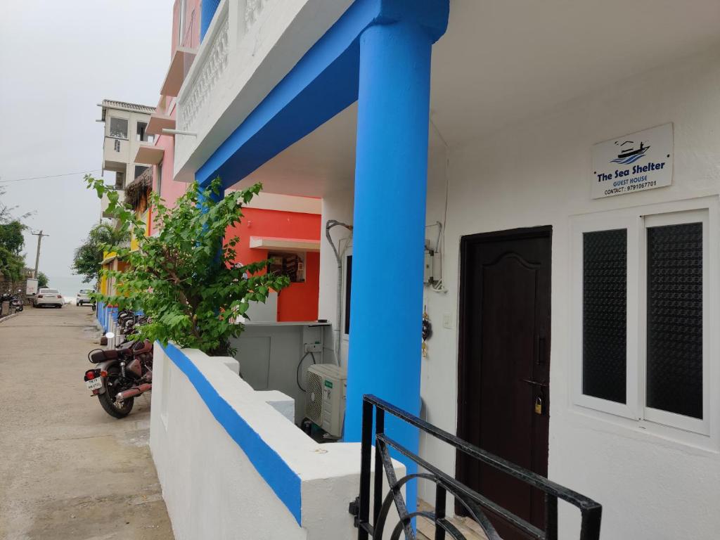 un bâtiment avec de la peinture bleue sur son côté dans l'établissement The Sea Shelter Home Stay, à Mahabalipuram