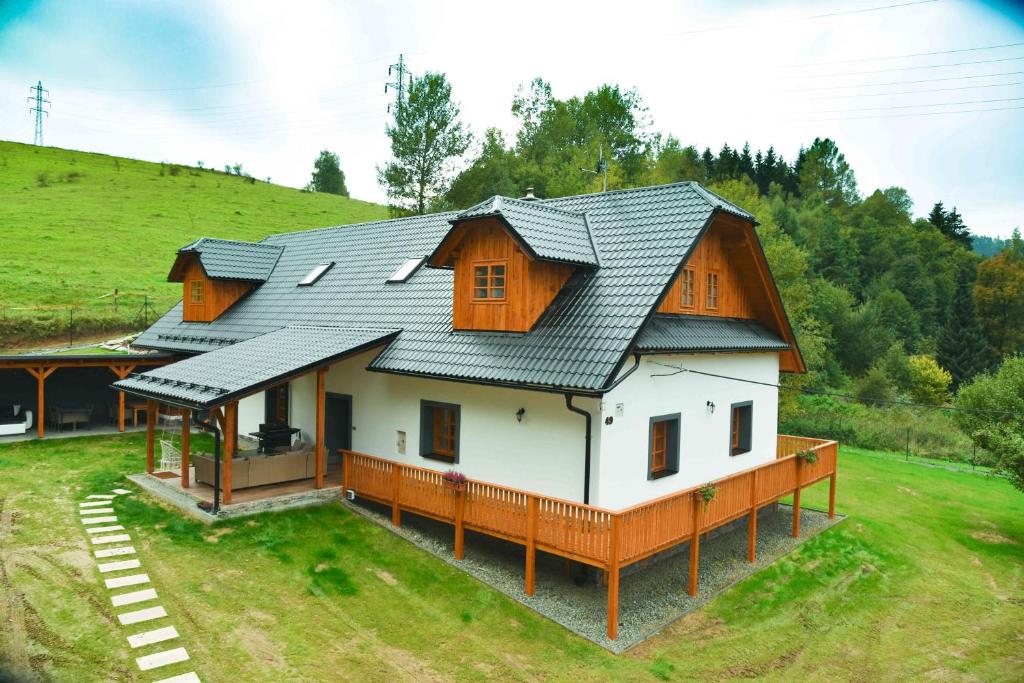 una casa con techo de metal en un campo en Chalupa Lilien pod Medvědí skálou Jeseníky, en Jindřichov