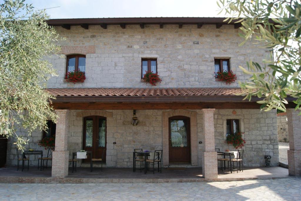 una casa in pietra con tavoli e sedie di fronte di DA LELLO - Bed & Relax a Torrecuso