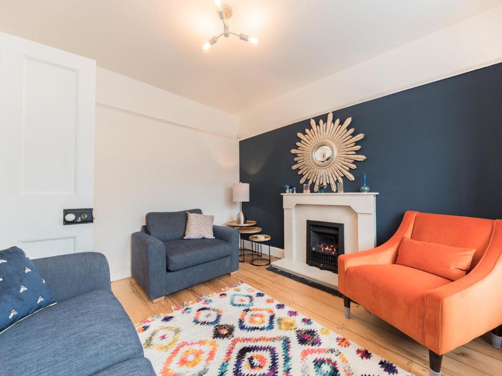 a living room with two chairs and a fireplace at Pass the Keys Cosy Cottage Nestled in the Center of Ulverston in Ulverston