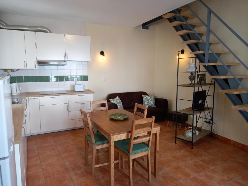 eine Küche und ein Esszimmer mit einem Tisch und einer Treppe in der Unterkunft Páteo dos Oliveira - Casa da Cocheira in Évora