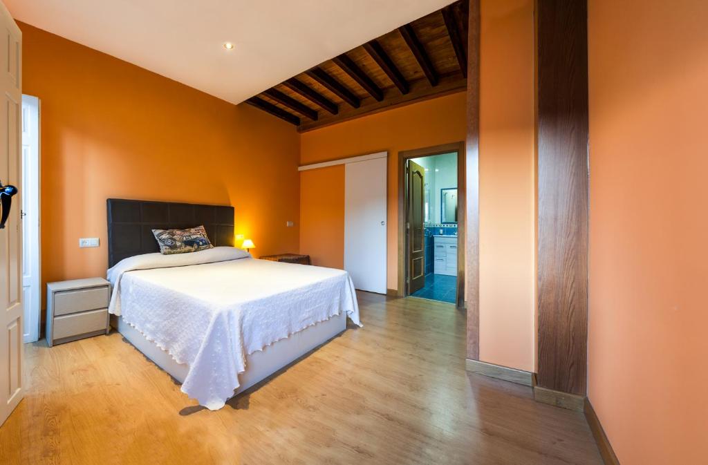 1 dormitorio con paredes de color naranja y 1 cama en Cerca del puerto deportivo y de la playa, en Cangas de Morrazo