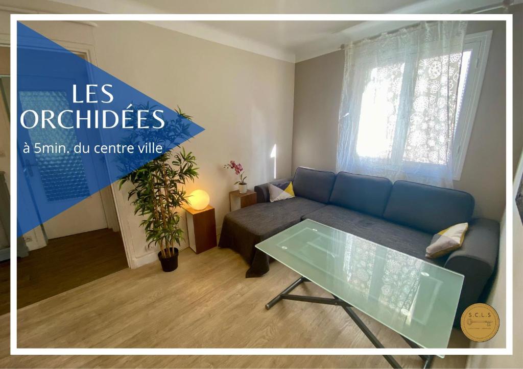 a living room with a blue couch and a table at Les Orchidées By SCLS Locations in Cannes