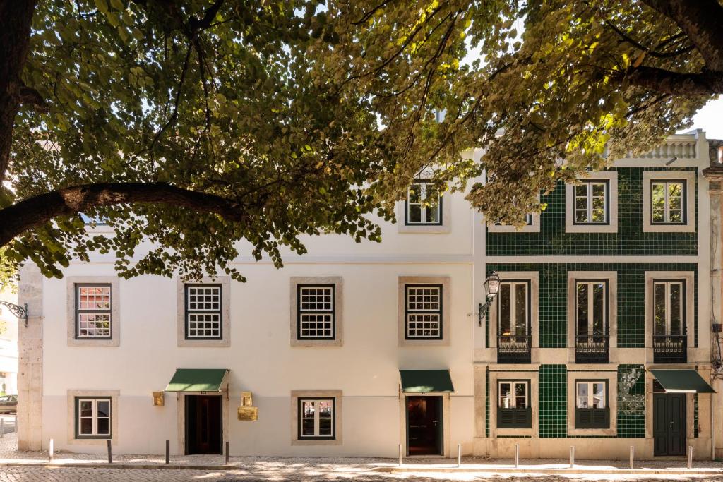 a large white building with green accents at Hotel das Amoreiras - Small Luxury Hotels of the World in Lisbon