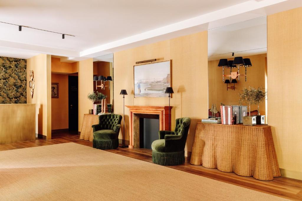 A spacious sitting area centered on a marble fireplace, with velvet chairs and a styled console.