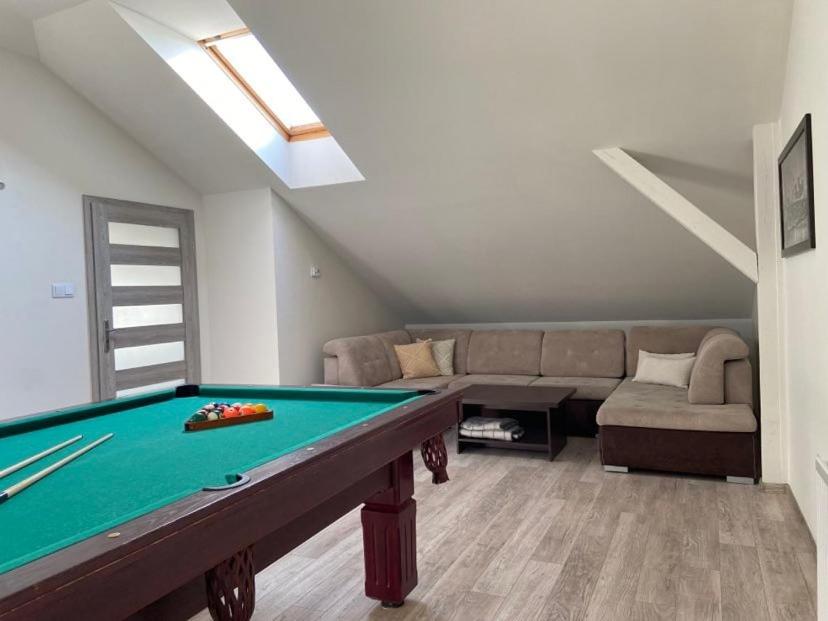 a living room with a pool table and a couch at Apartament Chopina in Suwałki